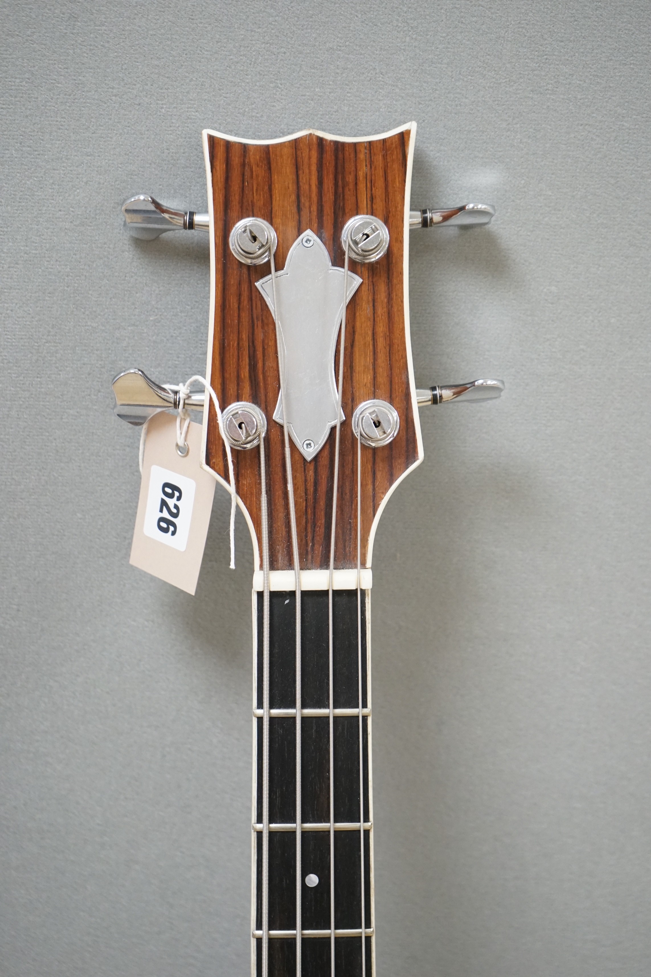 An Acoustic bass guitar, made by John Degay of Degay Guitars